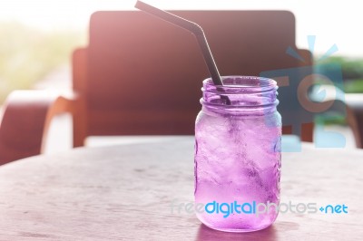 Iced Drink In Violet Glass In Coffee Shop Stock Photo