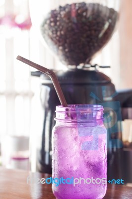 Iced Drink In Violet Glass In Coffee Shop Stock Photo