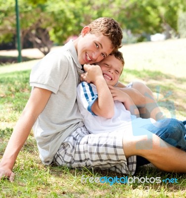 Image Of Brothers Sitting Outdoor Stock Photo