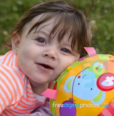 Infant Leaning On Her Ball Stock Photo