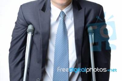 Injured Businessman With Crutches, Insurance Concept Stock Photo