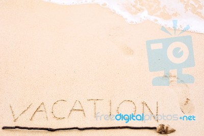 Inscription Of Vacation Written On Wet Yellow Beach Sand With Fo… Stock Photo