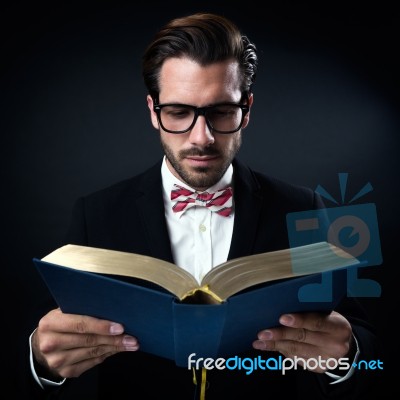 Intrigued Businessman With Glasses Reading A Book. Isolated On B… Stock Photo