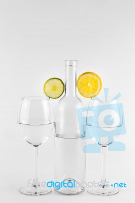 Isolated Bottle And Glasses With Lemon And Lime Stock Photo