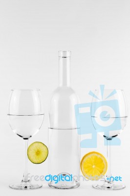 Isolated Bottle And Glasses With Lemon And Lime Stock Photo