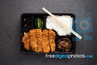 Japanese Food Tonkatsu Rice And Vegetable Take Away On Table Background Stock Photo