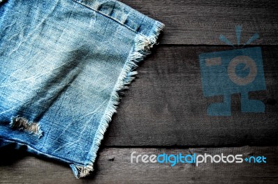 Jeans Lack On The Wooden Floor Stock Photo