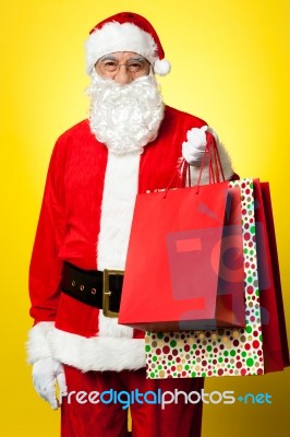 Joyous Santa Posing With Colorful Shopping Bags Stock Photo