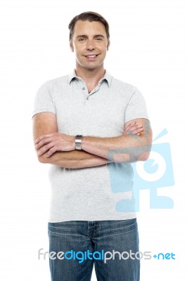 Joyous Young Man Posing With His Arms Crossed Stock Photo