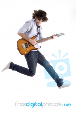 Jumping Young Male With Guitar Stock Photo