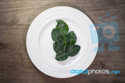 Kaffir Lime Leaves In Ceramic Dish On Wood Background Stock Photo