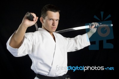 Karate Man With Katanas In Studio Stock Photo