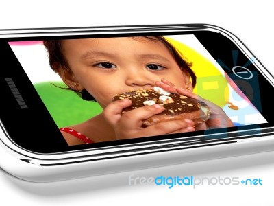 Kid Eating Donut On Mobile Screen Stock Image