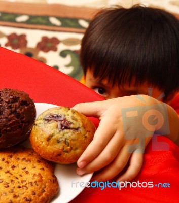 Kid Taking Cake From Table Stock Photo