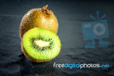 Kiwi Fruit On Black Stone Low Key Light Stock Photo