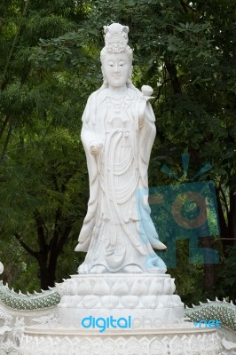 Kuan Yin Marble Sculpture Under Green Bamboo Background Stock Photo