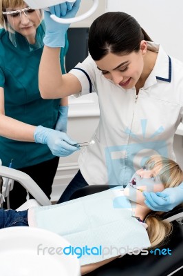 Lady Dentist Checking Girl's Teeth Stock Photo