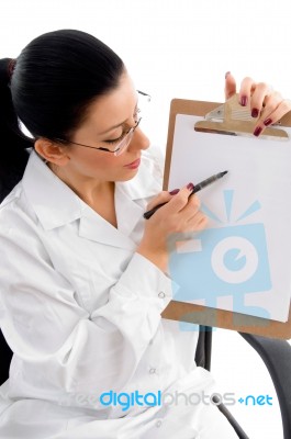 Lady Doctor Indicating Writing Pad Stock Photo