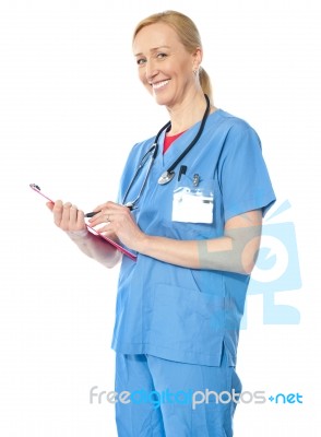 Lady Doctor Standing With Clipboard Stock Photo