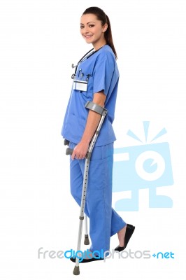 Lady Doctor Walking With Help Of Crutches Stock Photo