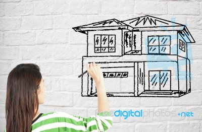 Lady Drawing House On Brick Wall Stock Photo