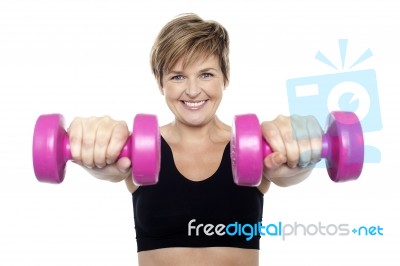 Lady Holding Pink Dumbbells. Arms Outstretched Stock Photo