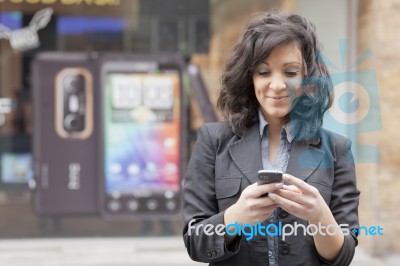 Lady Reading Sms In Street Stock Photo