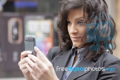 Lady Reading Sms In Street Stock Photo