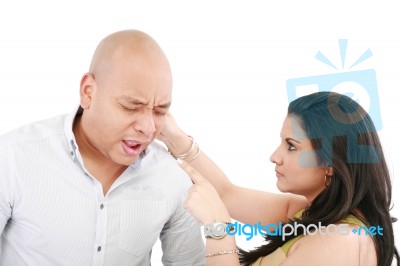 Lady Twisting Her Husband Ear Stock Photo