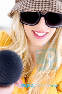 Lady Wearing Sunglasses Holding Mic Stock Photo