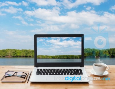 Laptop Computer And Coffee On Wood Workspace And Mangrove Forest Background Stock Photo