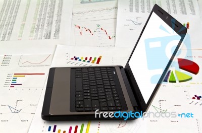 Laptop On Financial Graphs Stock Photo