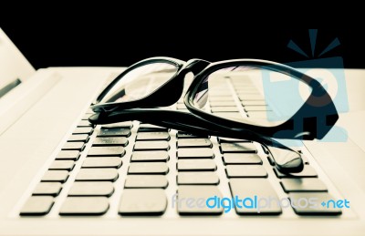 Laptop Or Notebook Button And Black Glasses  On Black Background Vintage Style Stock Photo