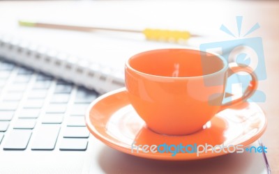 Laptop With Coffee Cup And Notepad On Desk Stock Photo