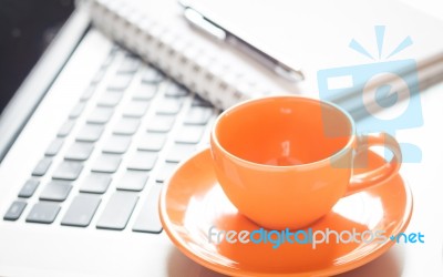 Laptop With Coffee Cup And Notepad On Desk Stock Photo