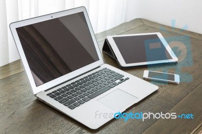 Laptop With Tablet And Smart Phone On Table Stock Photo