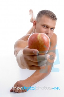 Laying Fit Guy Showing Apple Stock Photo