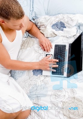 Laying Man Working On Laptop Stock Photo