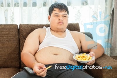 Lazy Overweight Male Sitting With Fast Food Stock Photo