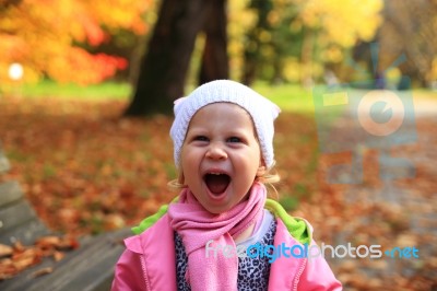 Lifestyle Portrait Of Little Happy Girl  In Autumn Park Stock Photo