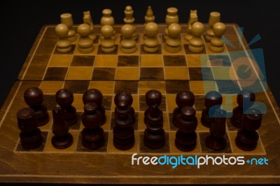 Light And Dark Wooden Chess Pieces On Chess Table Stock Photo