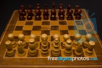 Light And Dark Wooden Chess Pieces On Chess Table Stock Photo