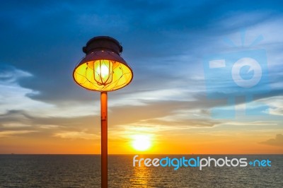 Lighting Of Warm Lamp And Lighting Of Sunset At Sea Stock Photo