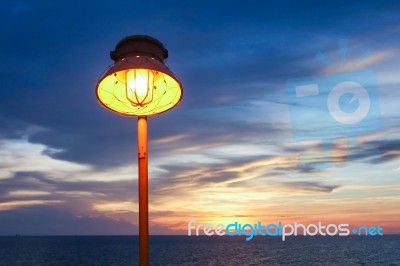 Lighting Of Warm Lamp And Lighting Of Sunset At Sea Stock Photo