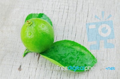 Lime And Leaves On Wood Stock Photo