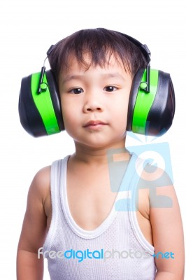 Little Asian Boy In A White Singlet Wearing Earmuffs Stock Photo