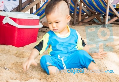 Little Asian Boy Playing Sand On The Beach Stock Photo