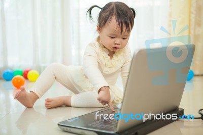 Little Asian Girl Play Laptop In Home Stock Photo