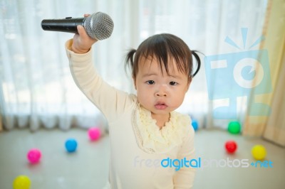 Little Asian Girl With Microphone Stock Photo