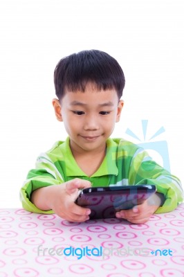 Little Asian (thai) Boy Using Digital Tablet At Desk Stock Photo